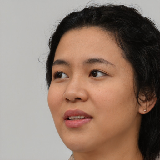 Joyful black young-adult female with long  black hair and brown eyes