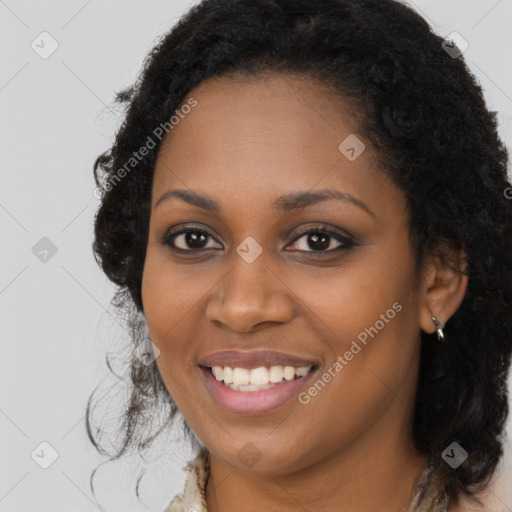 Joyful black young-adult female with long  brown hair and brown eyes