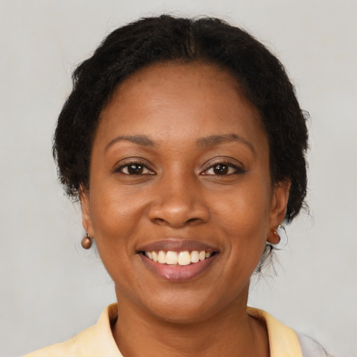 Joyful black adult female with medium  brown hair and brown eyes