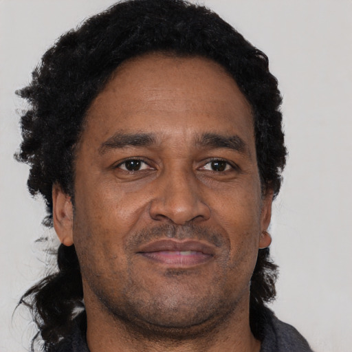 Joyful black adult male with short  black hair and brown eyes