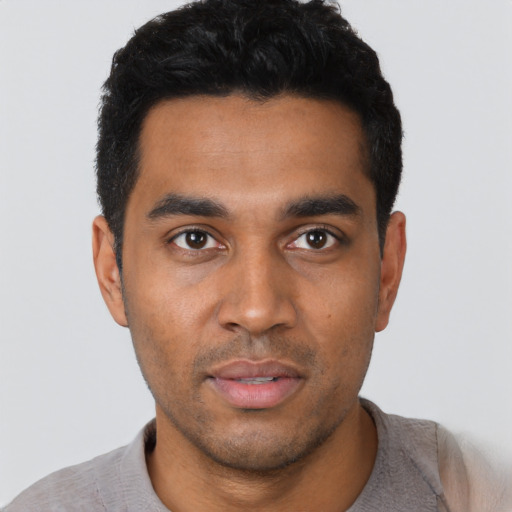 Joyful latino young-adult male with short  black hair and brown eyes