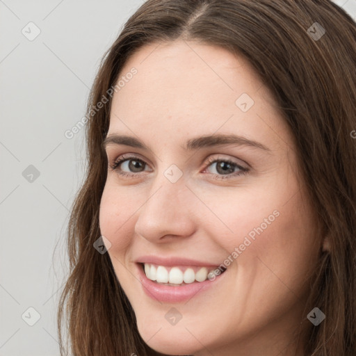 Joyful white young-adult female with long  brown hair and grey eyes