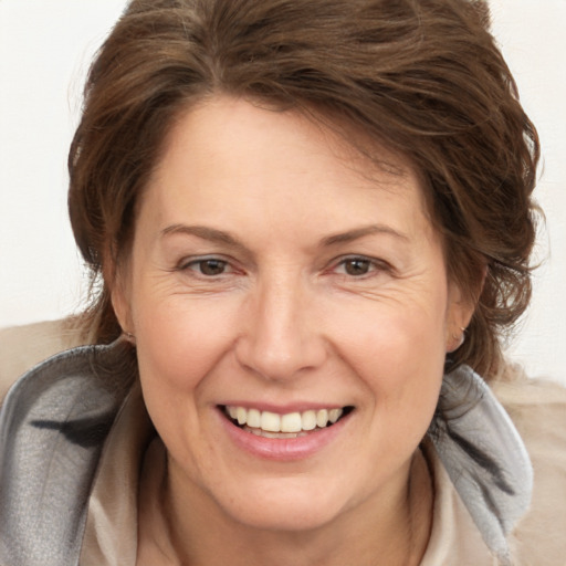 Joyful white adult female with medium  brown hair and brown eyes