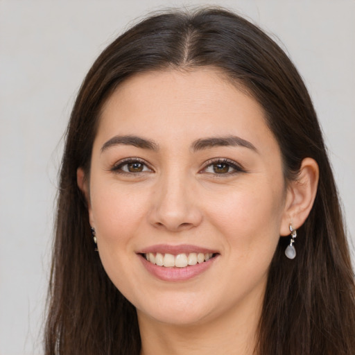 Joyful white young-adult female with long  brown hair and brown eyes