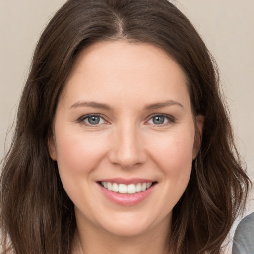 Joyful white young-adult female with long  brown hair and grey eyes