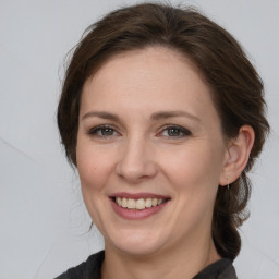 Joyful white young-adult female with medium  brown hair and grey eyes