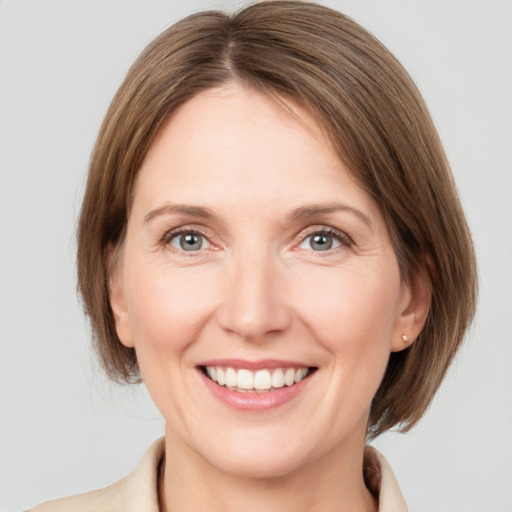 Joyful white adult female with medium  brown hair and grey eyes