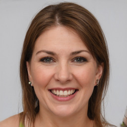 Joyful white young-adult female with medium  brown hair and grey eyes