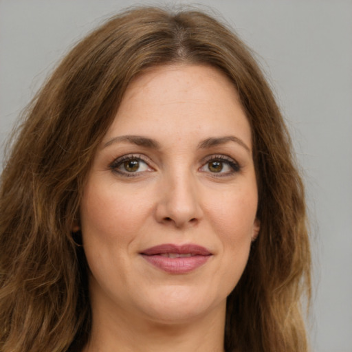 Joyful white young-adult female with long  brown hair and green eyes