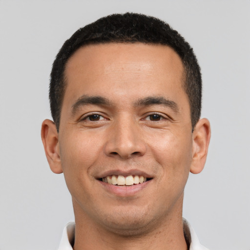 Joyful latino young-adult male with short  black hair and brown eyes