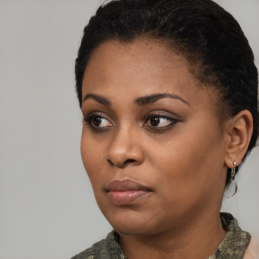 Joyful black young-adult female with short  black hair and brown eyes