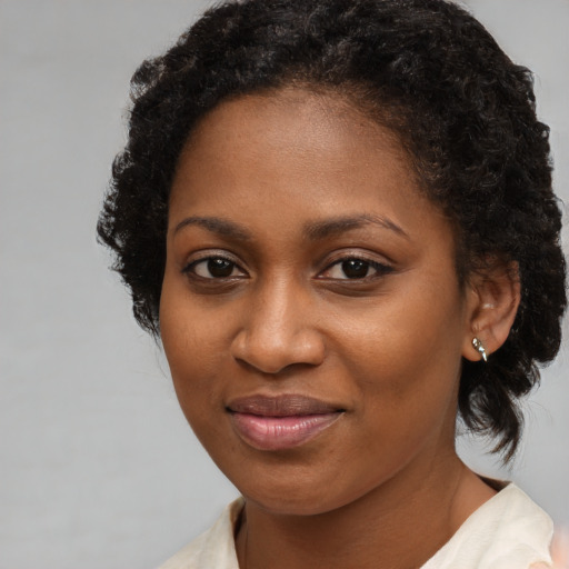 Joyful black young-adult female with medium  brown hair and brown eyes