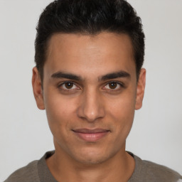 Joyful latino young-adult male with short  brown hair and brown eyes