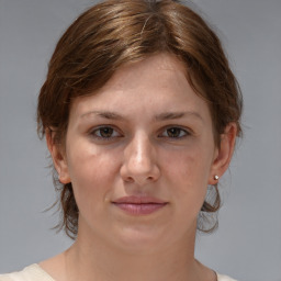 Joyful white young-adult female with medium  brown hair and grey eyes