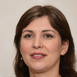 Joyful white adult female with long  brown hair and brown eyes