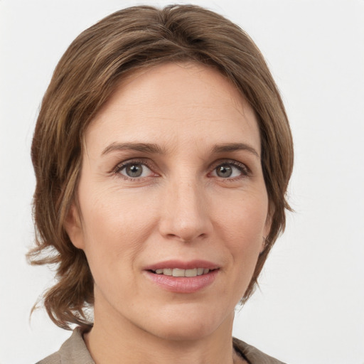 Joyful white adult female with medium  brown hair and grey eyes