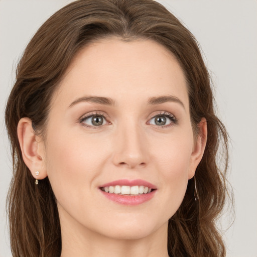 Joyful white young-adult female with long  brown hair and blue eyes