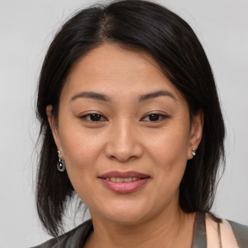 Joyful asian adult female with medium  brown hair and brown eyes