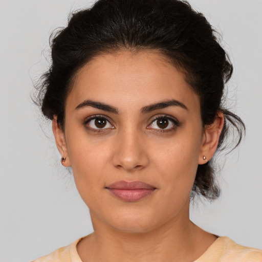 Joyful latino young-adult female with medium  brown hair and brown eyes