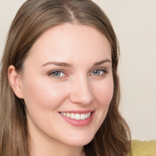 Joyful white young-adult female with long  brown hair and blue eyes