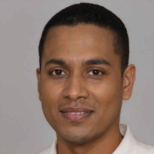 Joyful black young-adult male with short  black hair and brown eyes