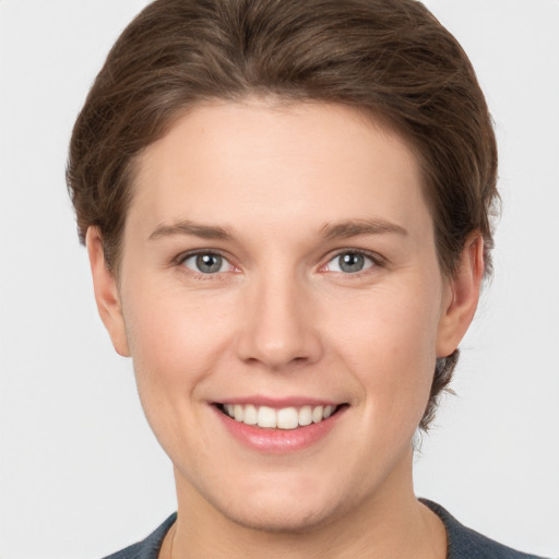 Joyful white young-adult female with short  brown hair and grey eyes