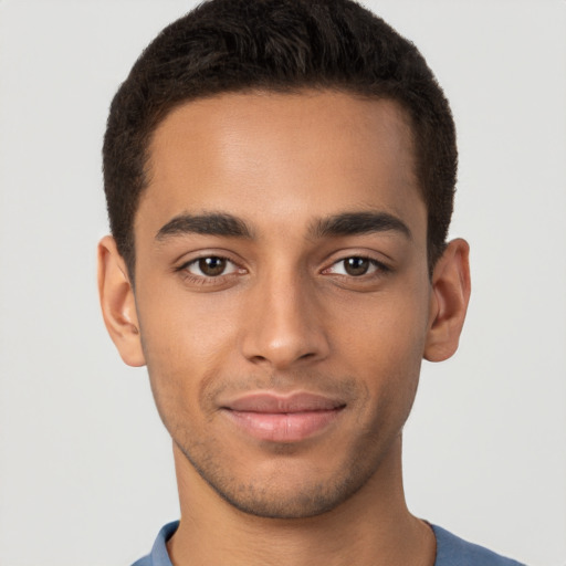 Joyful latino young-adult male with short  brown hair and brown eyes