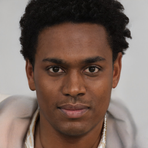 Joyful black young-adult male with short  brown hair and brown eyes