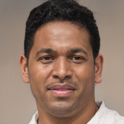 Joyful latino adult male with short  brown hair and brown eyes