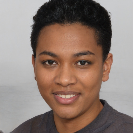 Joyful black young-adult female with short  black hair and brown eyes