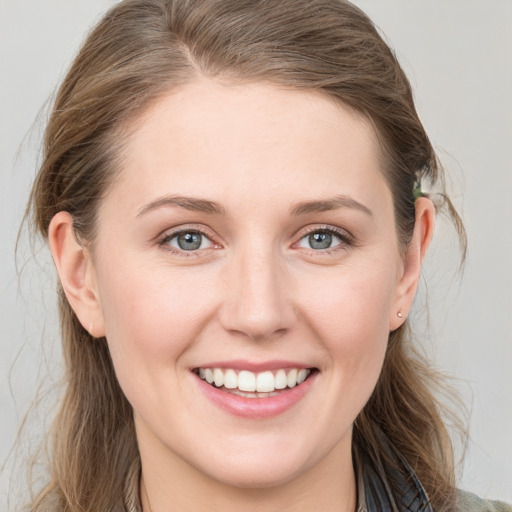 Joyful white young-adult female with long  brown hair and blue eyes