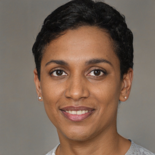 Joyful black young-adult female with short  black hair and brown eyes