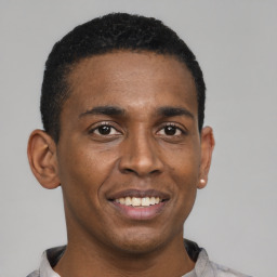 Joyful black young-adult male with short  black hair and brown eyes