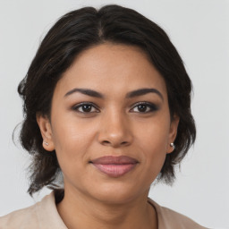 Joyful latino young-adult female with medium  brown hair and brown eyes