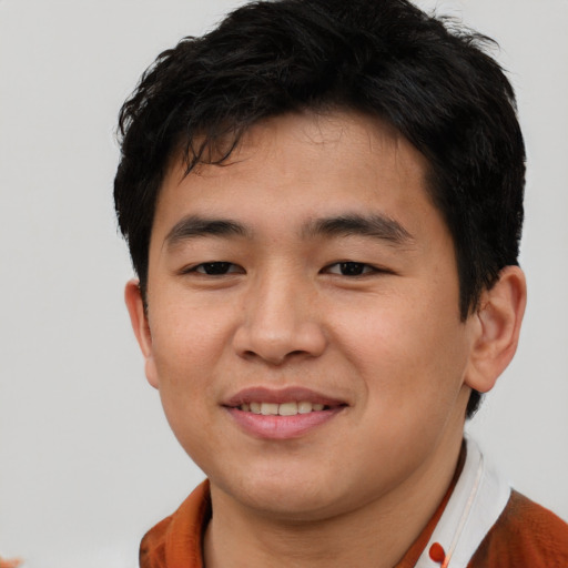 Joyful asian young-adult male with short  brown hair and brown eyes