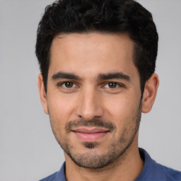 Joyful white young-adult male with short  black hair and brown eyes