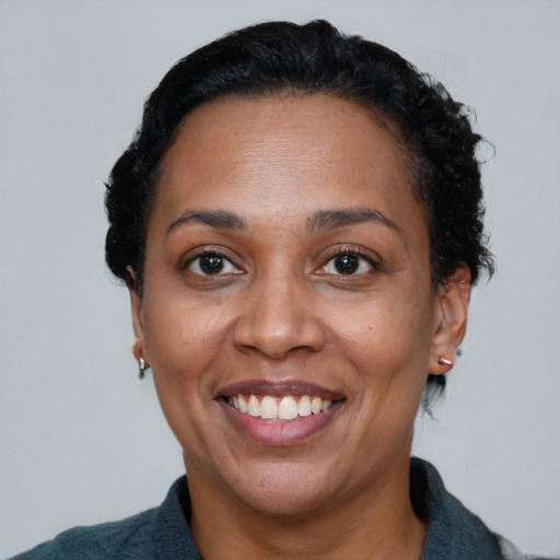 Joyful black adult female with short  black hair and brown eyes
