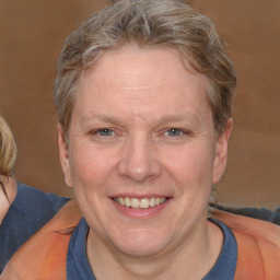 Joyful white adult female with medium  brown hair and blue eyes