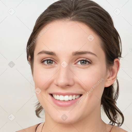 Joyful white young-adult female with medium  brown hair and grey eyes