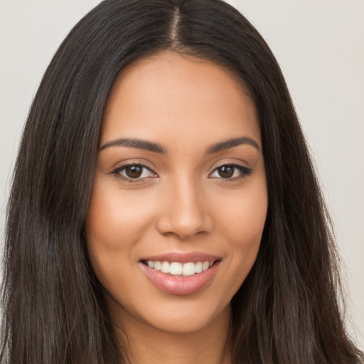 Joyful latino young-adult female with long  brown hair and brown eyes