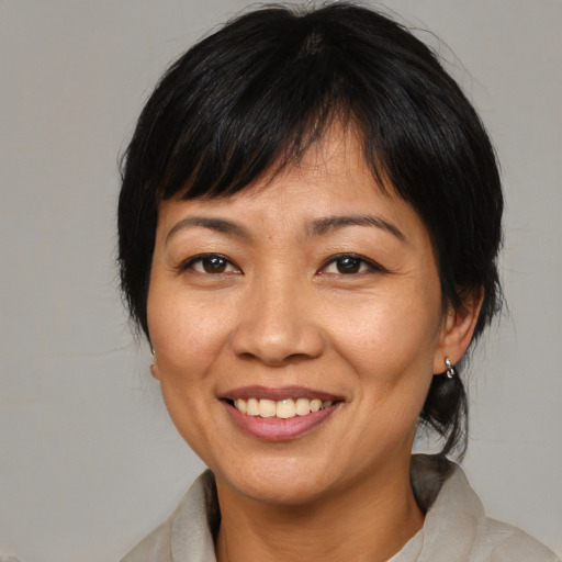 Joyful asian adult female with medium  brown hair and brown eyes