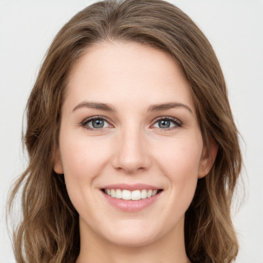 Joyful white young-adult female with long  brown hair and green eyes