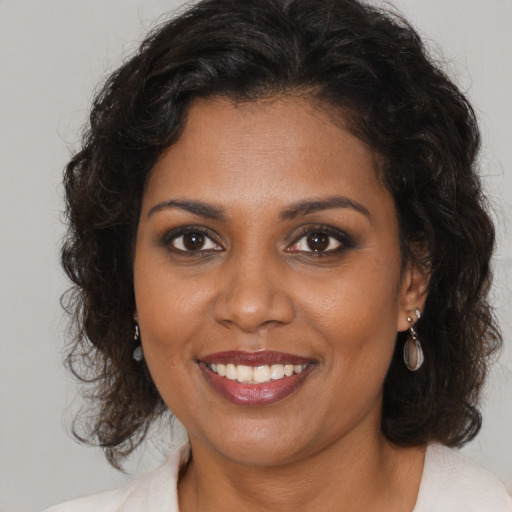 Joyful black young-adult female with medium  brown hair and brown eyes