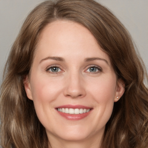 Joyful white young-adult female with long  brown hair and grey eyes