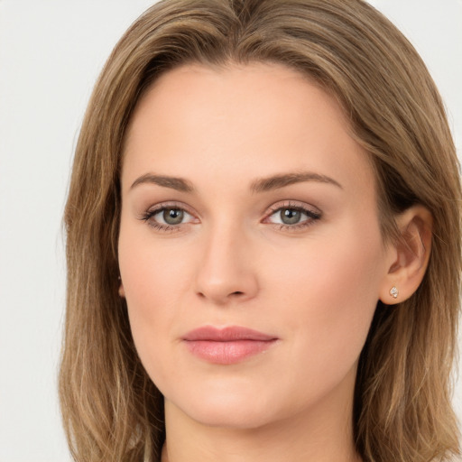 Joyful white young-adult female with long  brown hair and green eyes