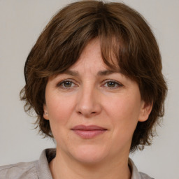 Joyful white adult female with medium  brown hair and grey eyes