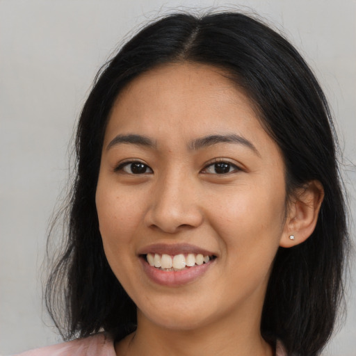 Joyful asian young-adult female with long  brown hair and brown eyes