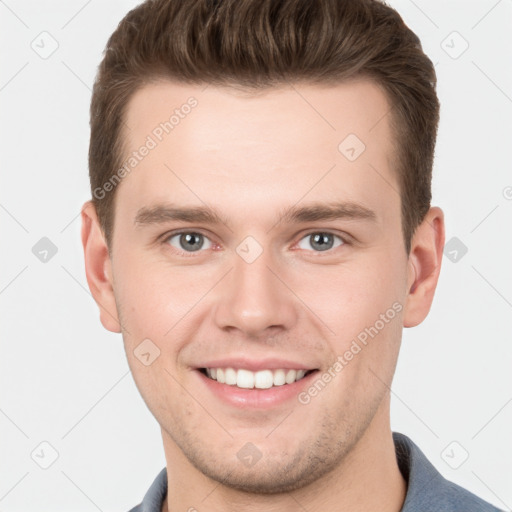 Joyful white young-adult male with short  brown hair and grey eyes