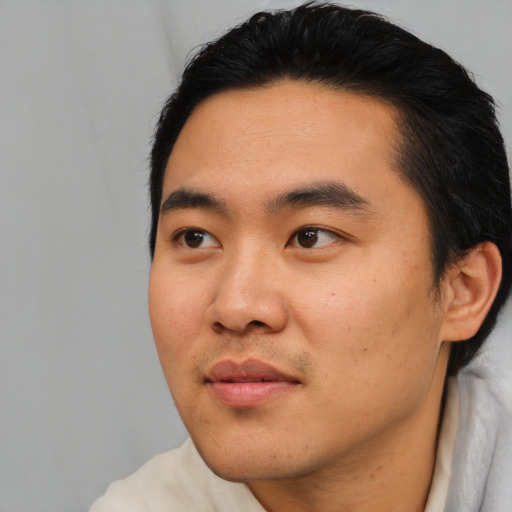 Joyful asian young-adult male with short  black hair and brown eyes