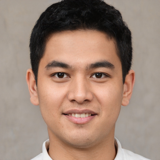 Joyful latino young-adult male with short  black hair and brown eyes